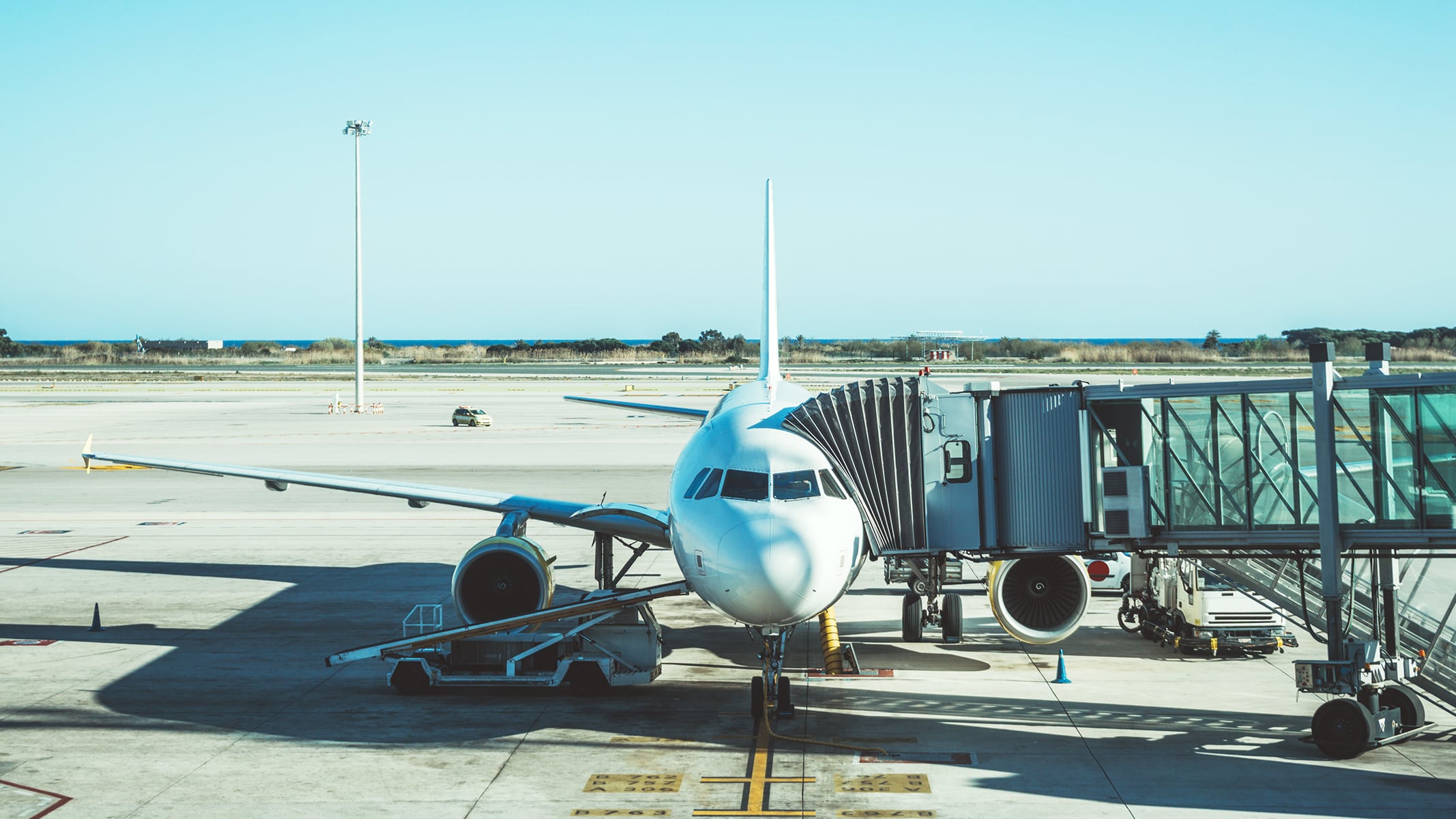 A commercial plane at an airplane gate, connected to a jet bridge