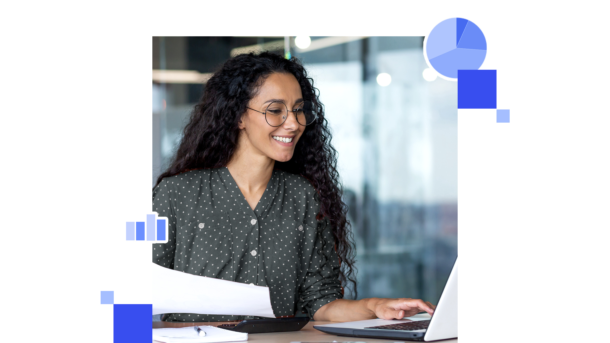 A business professional sits at a desk with a laptop, hands under chin, and smiles while looking to the left
