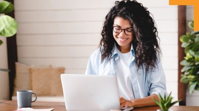 A person sitting at a table using a laptop 