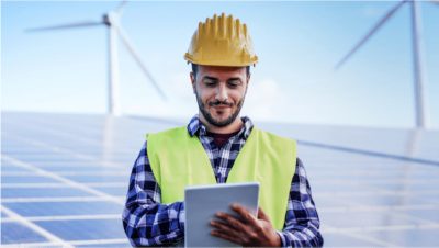 Man in a hardhat with windmills behind him