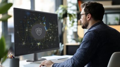   A male professional working on a computer deploying ArcGIS Enterprise on Microsoft Azure and monitoring data security