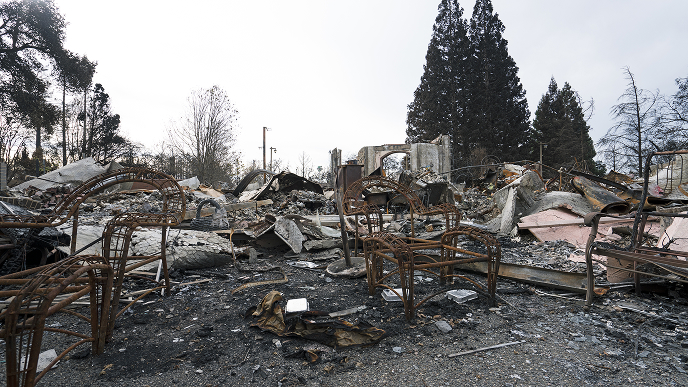 The wreckage of a home destroyed by a catastrophic storm beneath a dull overcast sky