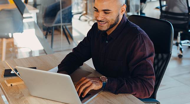 Profesjonalista pracuje na laptopie w otoczeniu biurowym.