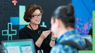 A person looking at an identification card while working at an event booth